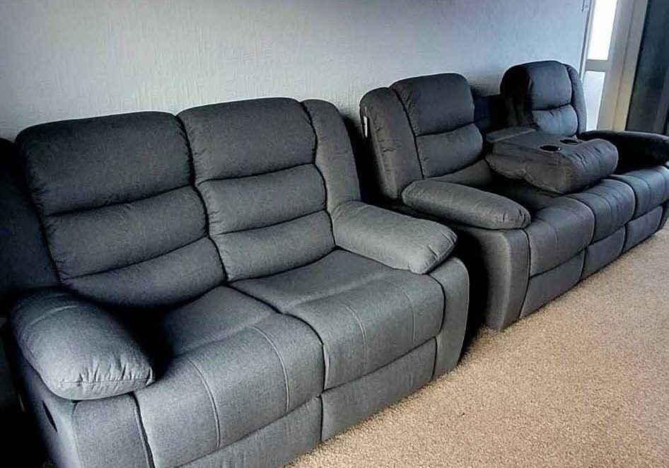 Dark grey recliner sofas in living room with trophies on the wall
